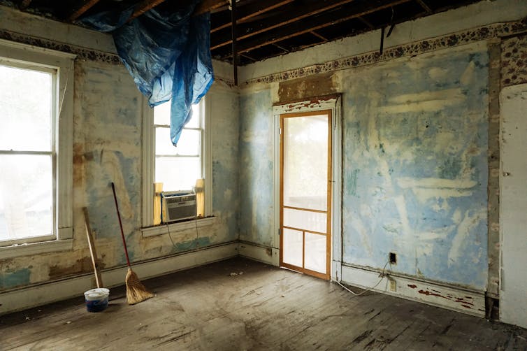 Flippa Spotlight An empty room in an abandoned house with peeling walls and construction tools.
